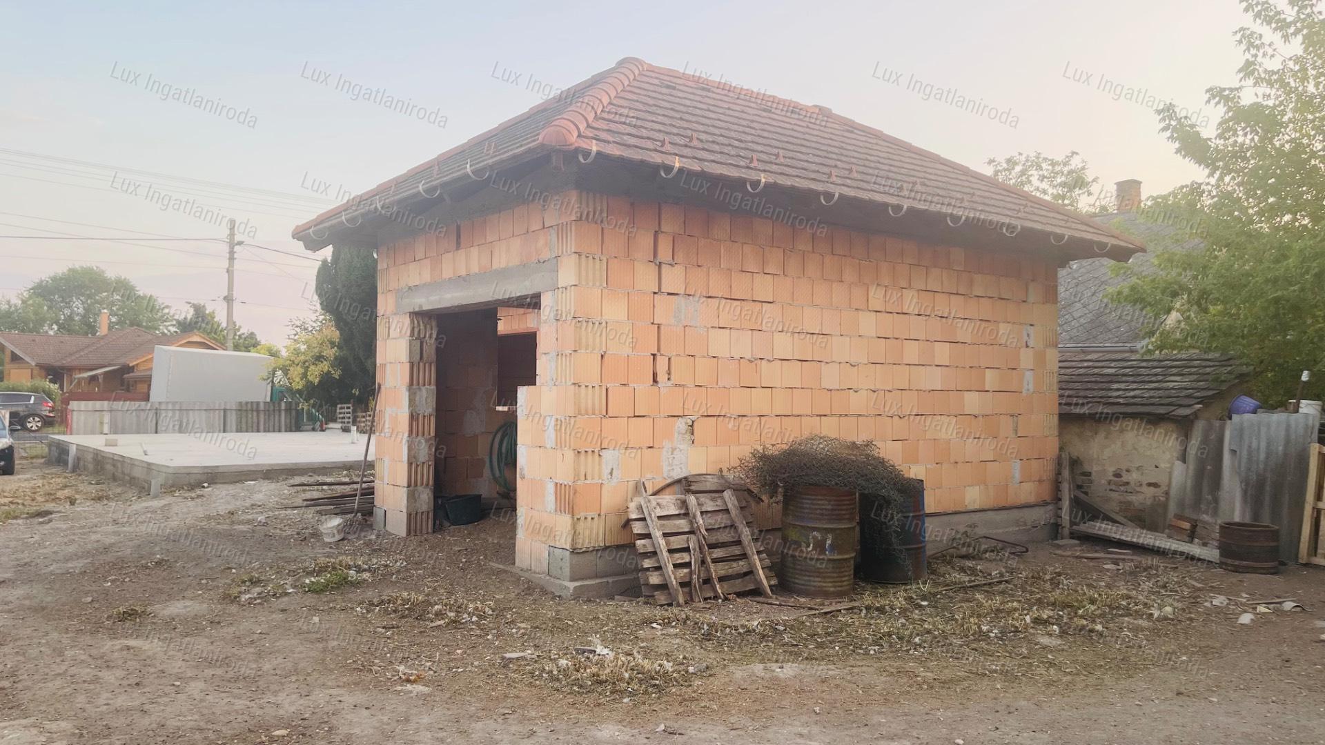 Szőnyben, a főúton 1059 m²-es telek befejezésre váró házikóval eladó!